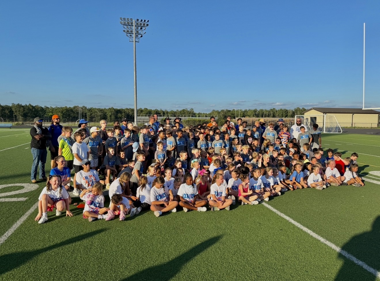 Large group of young athletes gathered on a football field